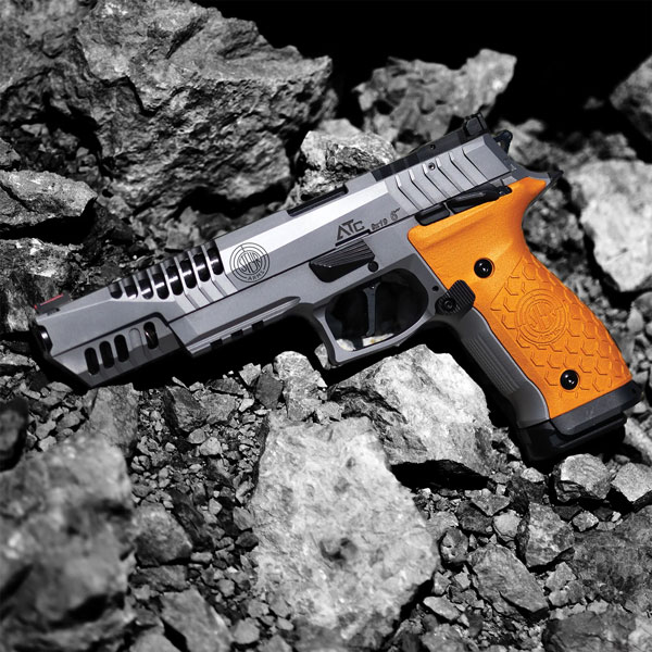 ATC Rock 6 OR von Steyr, Pistole liegt auf grauem, felsigen Untergrund, silberne Waffe mit orangebraunem Griff