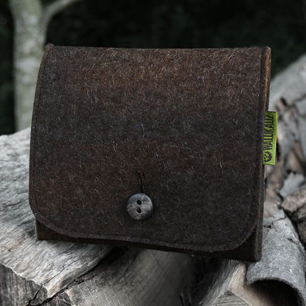 Filz Patronenetui von Waldkauz für Büchsenpatronen, Etui verschlossen mit einem Knopf, abgelegt auf Holz